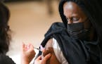 M Health Fairview nurse Terry Tran administers a COVID-19 booster shot into the arm of Muawiye Mohamed, 30, in December 2021 in Minneapolis.
