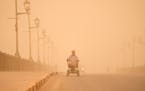 A man navigates his wheelchair on a street during a sand storm in Baghdad, Iraq, Monday, May 23, 2022. 