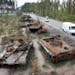 FILE - Cars pass by destroyed Russian tanks in a recent battle against Ukrainians in the village of Dmytrivka, close to Kyiv, Ukraine, May 23, 2022. T