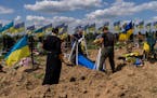 Undertakers lower the coffin of Ukrainian serviceman Oleksander Matyukhin, 32, in Kharkiv, eastern Ukraine, Monday, May 23, 2022. 