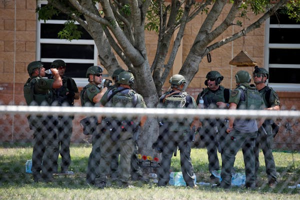 Law enforcement personnel stand outside Robb Elementary School following a shooting, Tuesday, May 24, 2022, in Uvalde, Texas.