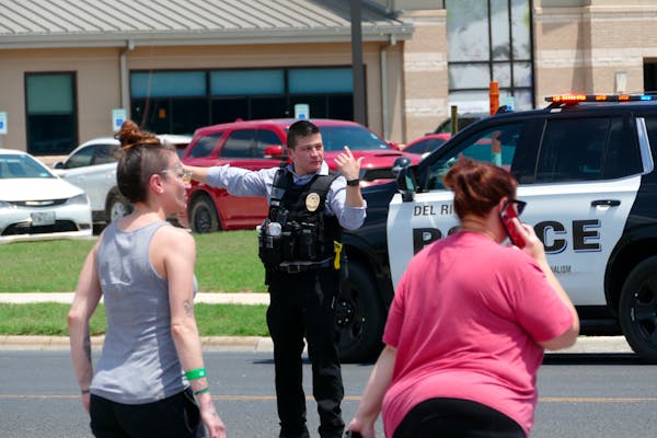 A law enforcement officer helped people cross the street at Uvalde Memorial Hospital after a shooting was reported at Robb Elementary School on Tuesda