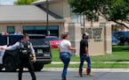 A law enforcement officer helps people cross the street at Uvalde Memorial Hospital on Tuesday after a shooting was reported at Robb Elementary School