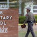A state trooper walks past the Robb Elementary School sign in Uvalde, Texas, Tuesday, May 24, 2022, following a deadly shooting at the school. 
