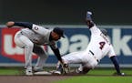 Minnesota Twins’ Carlos Correa (4) slides safely to second for a double ahead of the tag from Detroit Tigers shortstop Willi Castro during the first