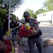 A police officer takes flowers from a resident to place them at a makeshift memorial outside Robb Elementary School in Uvalde, Texas, on Wednesday.