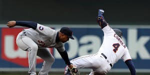 Carlos Correa of the Twins slid into second after a first-inning double as Jonathan Schoop of the Tigers applied a late tag.
