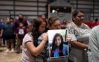 Esmeralda Bravo, center, held a photo of her granddaughter, Nevaeh, one of the Robb Elementary School shooting victims, as she is comforted by Nevaeh�