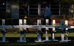 A law enforcement officer walks past crosses bearing the names of Tuesday’s shooting victims at Robb Elementary School in Uvalde, Texas, on Thursday