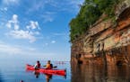 Paddlers on a sea cave tour at Apostle Islands National Lakeshore, operated by Lost Creek Adventures.