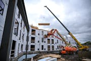 A crane lifts a roof section as construction is underway Thursday, May 26, 2022 at Reeve Lakeside Apartments in Robbinsdale, Minn.. New census figures
