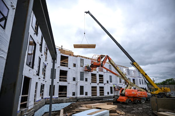 A crane lifts a roof section as construction is underway Thursday, May 26, 2022 at Reeve Lakeside Apartments in Robbinsdale, Minn.. New census figures