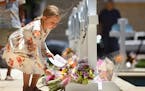 Kymber Guzman, 8, places flowers at a memorial for the victims of a mass shooting in Uvalde, Texas, on Thursday, May 26, 2022. Nineteen students and t