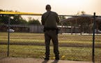 A state trooper with the Texas Highway Patrol pulls crime scene tape around a fence behind Robb Elementary School in Uvalde, Texas, on Wednesday morni