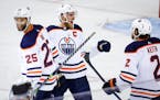 Oilers center Connor McDavid celebrates his goal against the Calgary Flames with defensemen Darnell Nurse, left, and Duncan Keith during overtime in G