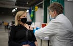 Tracey Hickey of Edina received her second COVID-19 vaccine booster shot from Joan Wynne at the community vaccination site at the Mall of America in B