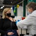 Tracey Hickey of Edina received her second COVID-19 vaccine booster shot from Joan Wynne at the community vaccination site at the Mall of America in B