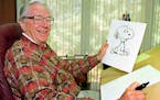 In this Feb. 12, 2000, photo, cartoonist Charles Schulz displays a sketch of his beloved character “Snoopy” in his office in Santa Rosa, Calif. 