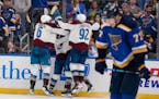 Teammates engulfed the Avalanche’s Darren Helm after his game-winning goal with 5.6 second left in regulation as the Blues’ Niko Mikkola reacted i