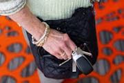 Sharon McWhite tucked her keys into a zipper pocket in her purse after entering her office earlier this month in Edina.