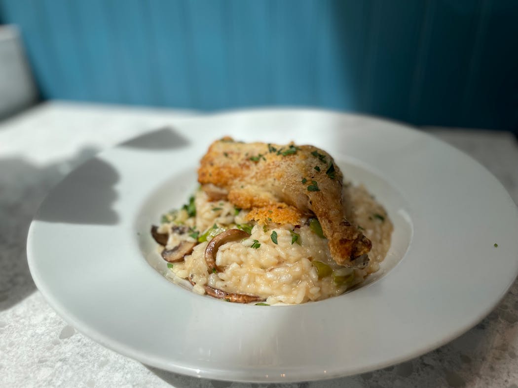 Chicken risotto is studded with mushrooms and topped with crusty chicken.