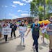 Annandale High School freshman Landon Nelson leads a group of students walking out of school Wednesday, June 1, to protest district leaders calling LG