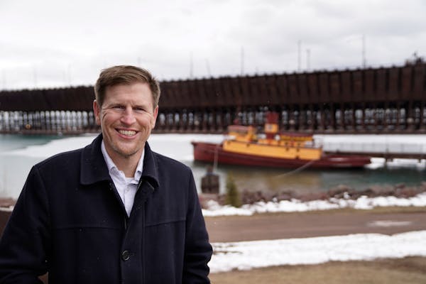 Chris Swanson posed for a portrait near the Edna G, a tugboat that worked the Great Lakes and is now preserved as a museum, and the nearby Two Harbors