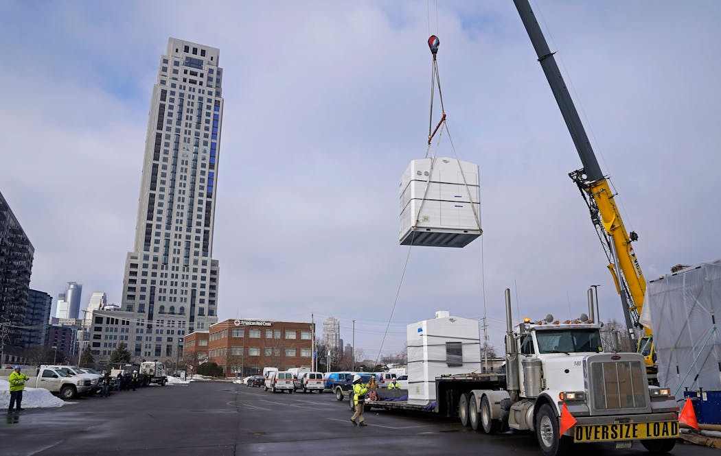 A crane moves an 17,000-pound electrolyser into place at a CenterPoint gas facility in downtown Minneapolis for the utility's 