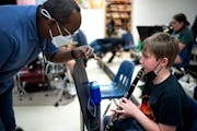 Ed Barlow, left, the band teacher at Anwatin Middle School shows Alex Rennie how to position his fingers on the clarinet. Barlow was on the Minneapoli