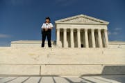 A police officer stands watch outside the Supreme Court following a leaked draft opinion that the Supreme Court has potentially voted to overturn Roe 