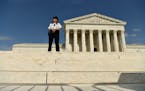 A police officer stands watch outside the Supreme Court following a leaked draft opinion that the Supreme Court has potentially voted to overturn Roe 