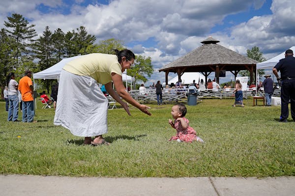 Ashley Goodsky of Nett Lake encourages her 10-month-old daughter Aleena Goodsky to walk during a ceremony commemorating the restoration of more than 2
