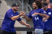 Eric Kendricks (54) celebrated with Vikings teammate Harrison Phillips after hitting a home run during the Adam Thielen Foundation charity softball ga