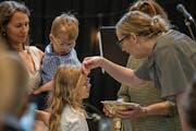 Pastor Sara Wilhem Garbers blessed Fiona Watson while Erin Watson held son Julian during a baptism ceremony at Meetinghouse Church in Edina on June 12
