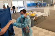 Jorge Macias administers a rapid COVID-19 test Thursday, June 9, 2022 at the COVID-19 test-to-treat site at the Starlite Center in Brooklyn Park, Minn