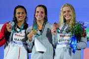 Silver medalist Kylie Masse, gold medalist Regan Smith of the United States and bronze medalist Claire Curzan posed on the podium of the women 100m ba