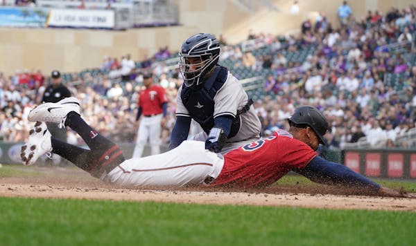 Minnesota Twins' Byron Buxton beats the tag by New York Yankees catcher Jose Trevino to score from third base on a sacrifice fly by Max Kepler during 