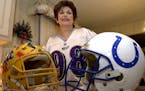 Rosemarie Siragusa, mother of Baltimore Revens 340-pound tackle Tony “The Goose” Siragusa, posed with his Pitt and Colts helmets at her home in Ke