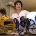 Rosemarie Siragusa, mother of Baltimore Revens 340-pound tackle Tony “The Goose” Siragusa, posed with his Pitt and Colts helmets at her home in Ke