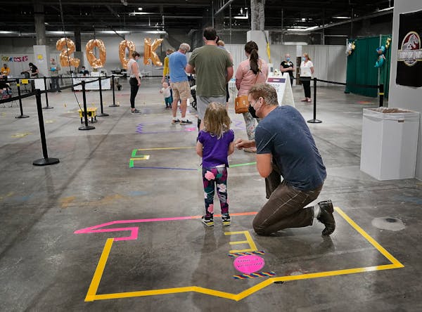 Adam Clark and his daughter Athena Clark, 3, of Minneapolis waited patiently for Athena to receive her first COVID-19 shot at the state’s Mall of Am