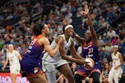 In her first game back after an injury, Lynx center Sylvia Fowles split the defense of Phoenix forward Brianna Turner (21) and center Tina Charles on 