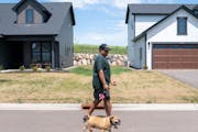New resident Michael Englandwalked his dog in the Canvas at Woodbury leased single-family homes complex.