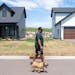 New resident Michael England, who moved in about a month ago, walked his dog in the Canvas at Woodbury leased single-family homes complex Thursday in 