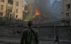 Firefighters and soldiers respond at the site of a Russian missile strike in central Kyiv, Ukraine on Sunday, June 26, 2022. 
