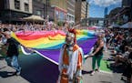 Participants bearing the Pride flag celebrate during the Twin Cities LGBTQ+ Pride March on Hennepin Avenue in downtown Minneapolis on Sunday.
