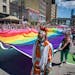 Participants walk with a rainbow Pride flag during the Twin Cities LGBTQ+ Pride March on Hennepin Avenue in downtown Minneapolis on Sunday. More than 