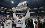 Avalanche center Nathan MacKinnon lifted the Stanley Cup after the team defeated the Lightning on Sunday night in Tampa, Fla.