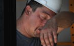 FILE - In this Monday, July 18, 2011 photo, John Kramer wipes away perspiration while working on the construction site for a new Jimmy John's in St. P