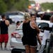Onlookers stand near the scene where a semitrailer with multiple dead bodies was discovered, Monday, June 27, 2022, in San Antonio. 