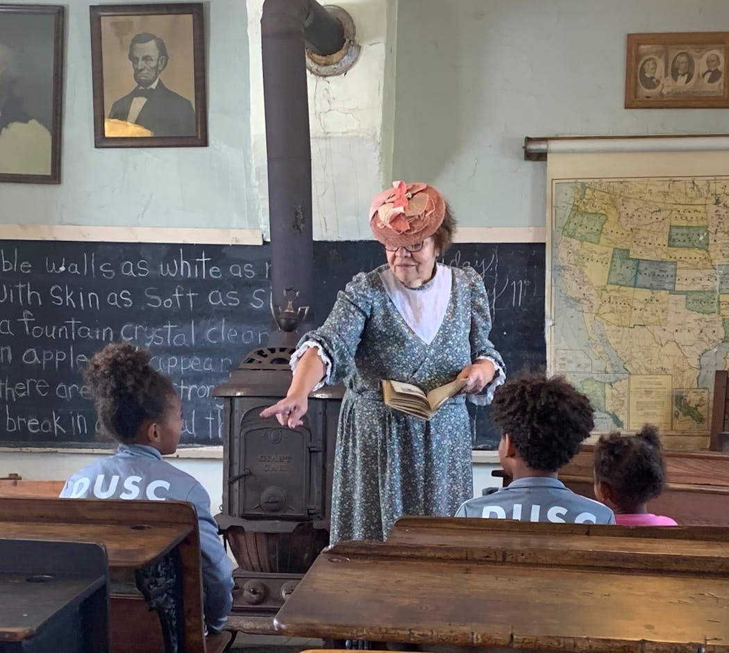 A retired schoolteacher quizzes kids on the life of Laura Ingalls Wilder in the one-room schoolhouse near the Ingalls Homestead.